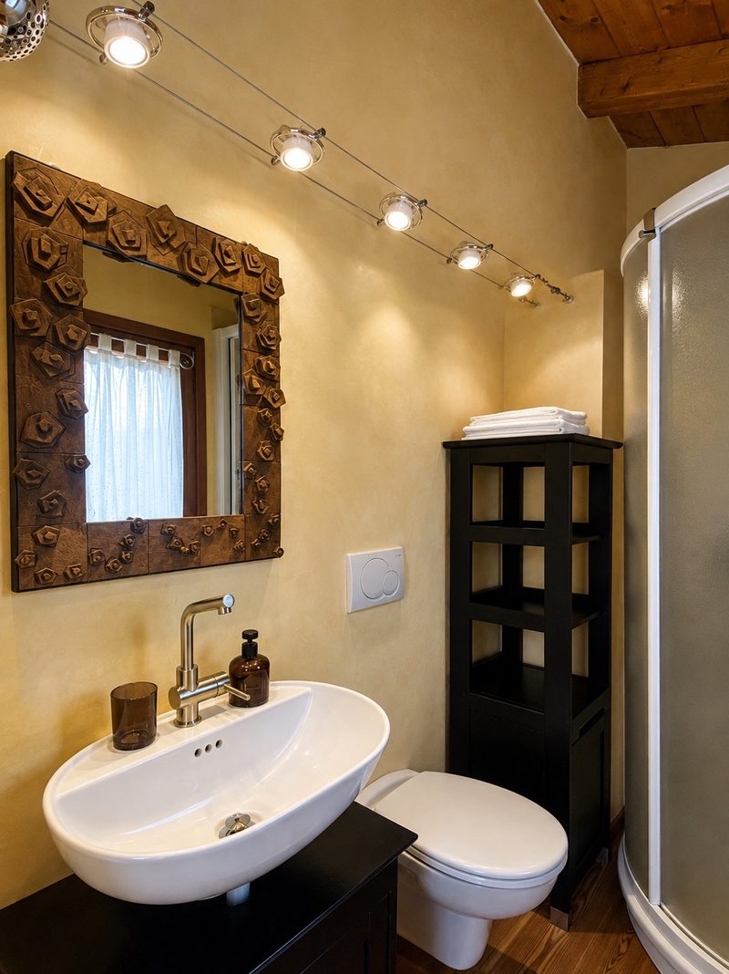 Bucaneve's bathroom with a corner shower and carved wooden mirror