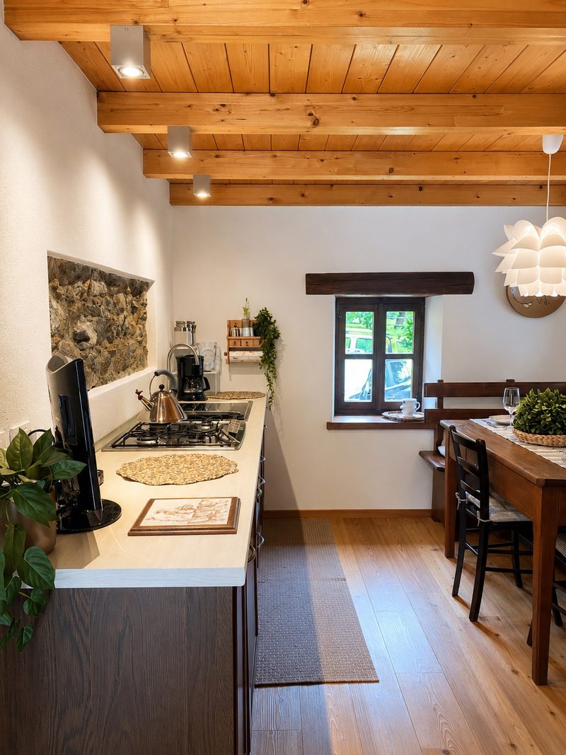 Bucaneve's living space, with the kitchen and dining table under the timber-beamed ceiling