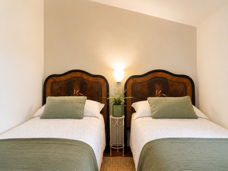 Ciclamino's twin room with matching antique beds and sage-green covers