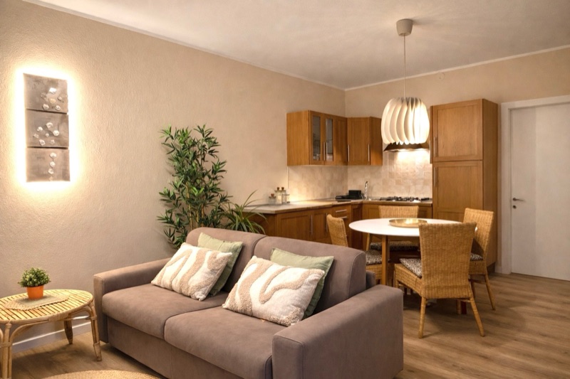 The living room of Giardino with a soft sofa, dining table and open kitchen