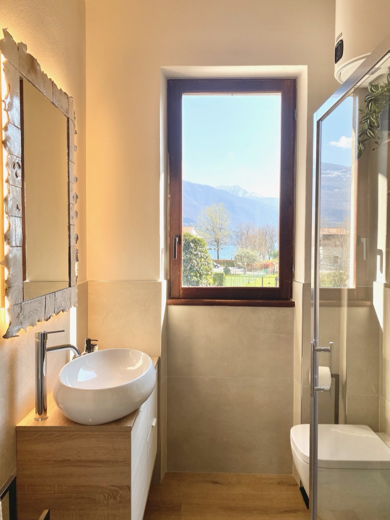 The bathroom of Panorama with a window over the lake and mountains