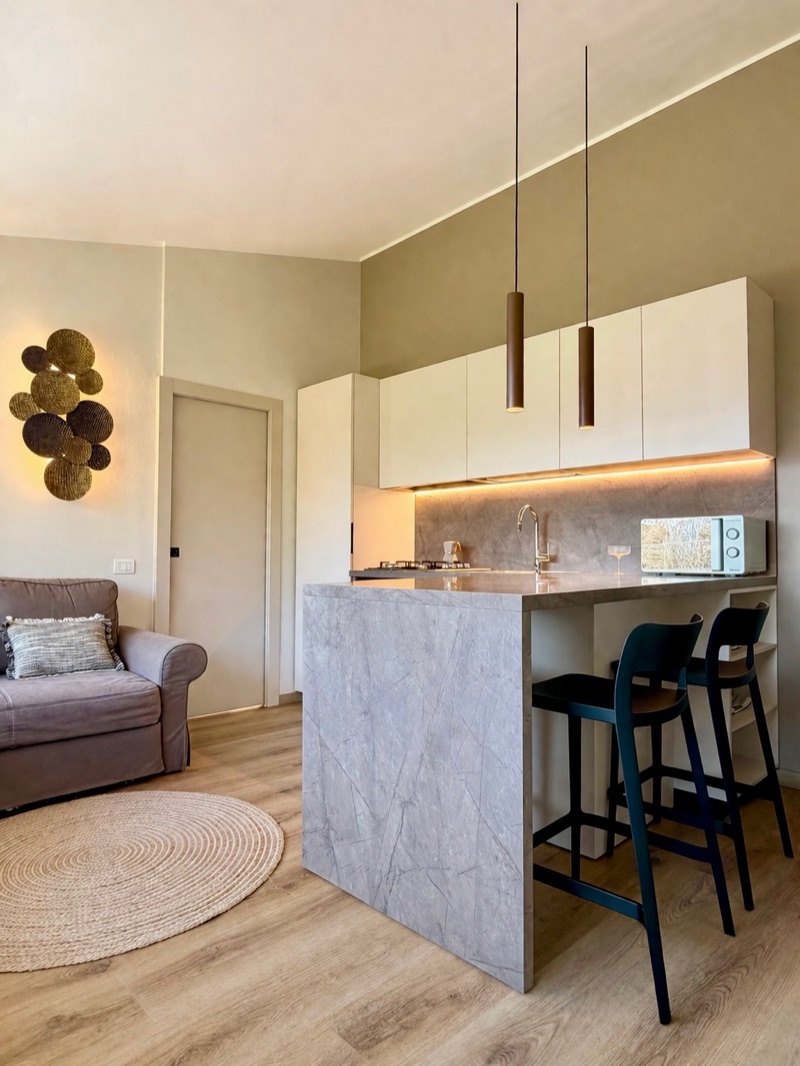 Panorama's kitchen island in grey stone with pendant lights and bar stools