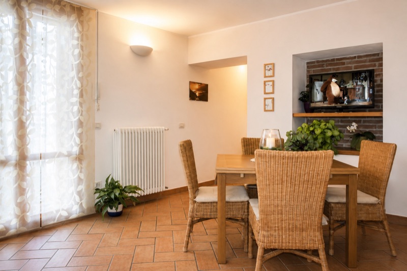 The dining room of Dalì with a wicker-chaired table and an exposed brick niche