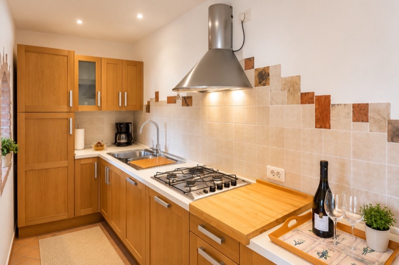 Dalì's wooden kitchen with gas hob, chopping board and a bottle of wine ready on the counter