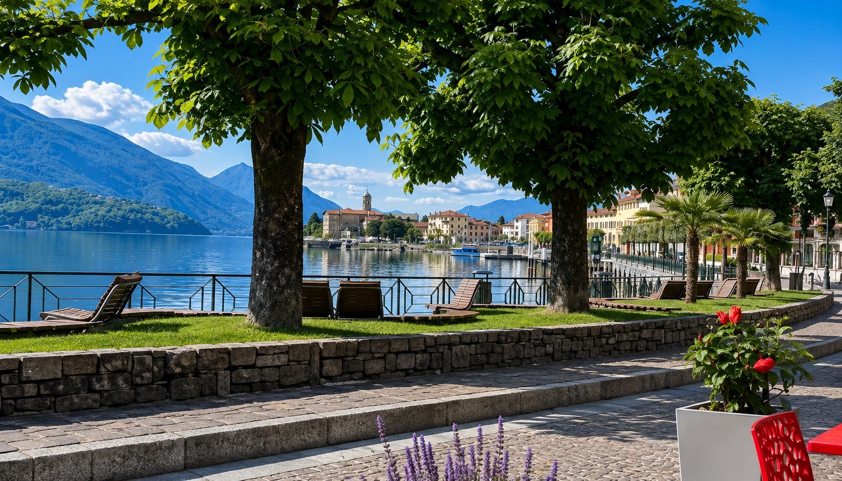 The town of Gravedona framed between two large trees, with the bell tower and lakefront houses, mountains in the background