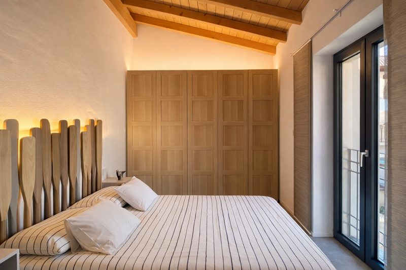 The master bedroom with a full wall of oak wardrobes and doors onto a small balcony