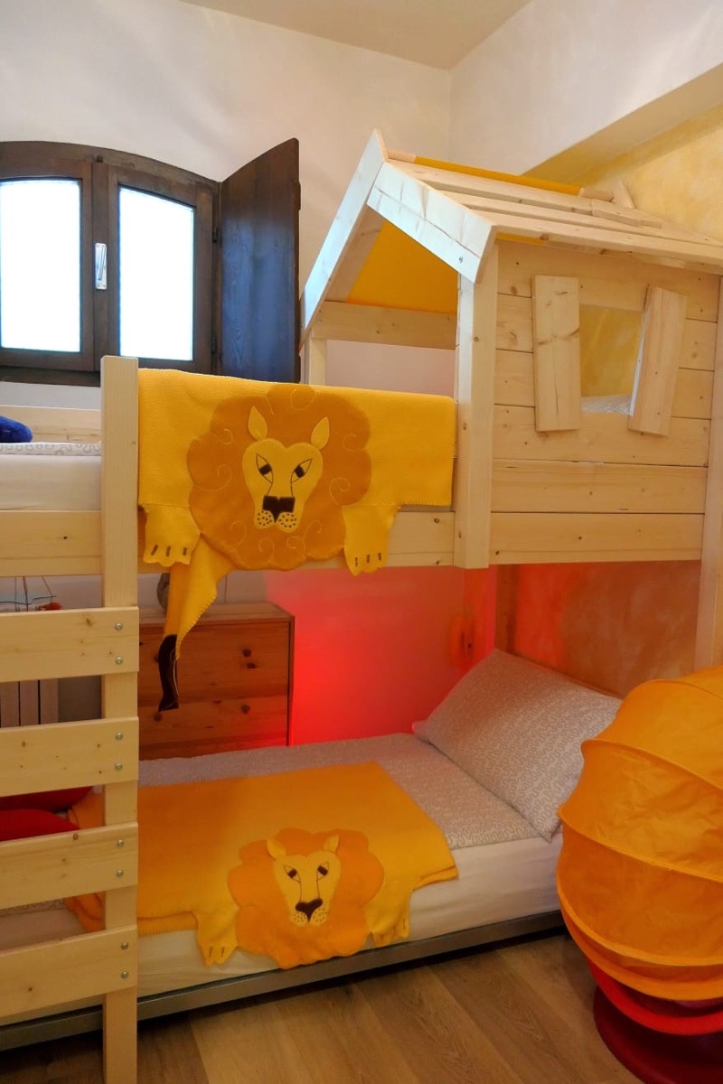 Picasso's children's room: a wooden cabin bunk bed dressed in yellow lion blankets