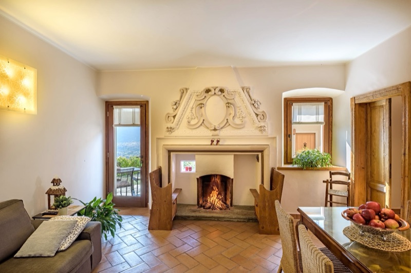 Sole Luna's living room with a lit fire in the great sculpted stone fireplace