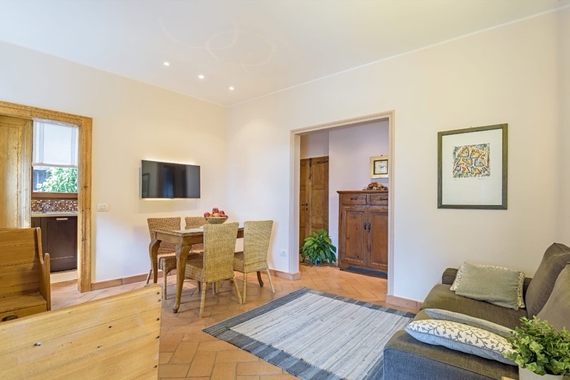 The dining corner of Sole Luna with wicker chairs, terracotta floor and antique sideboard